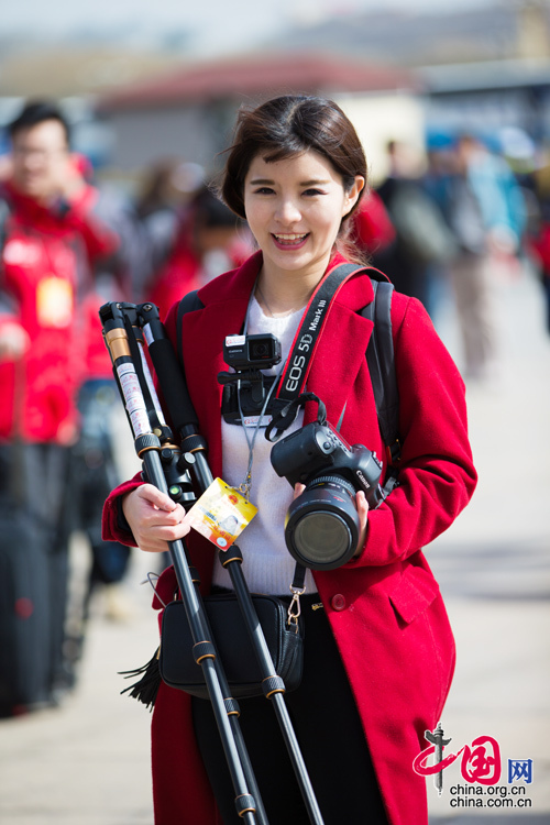 2016年兩會，人民大會大堂前，一位笑容燦爛的紅衣女記者正步入大會堂。中國網(wǎng) 鄭亮 攝