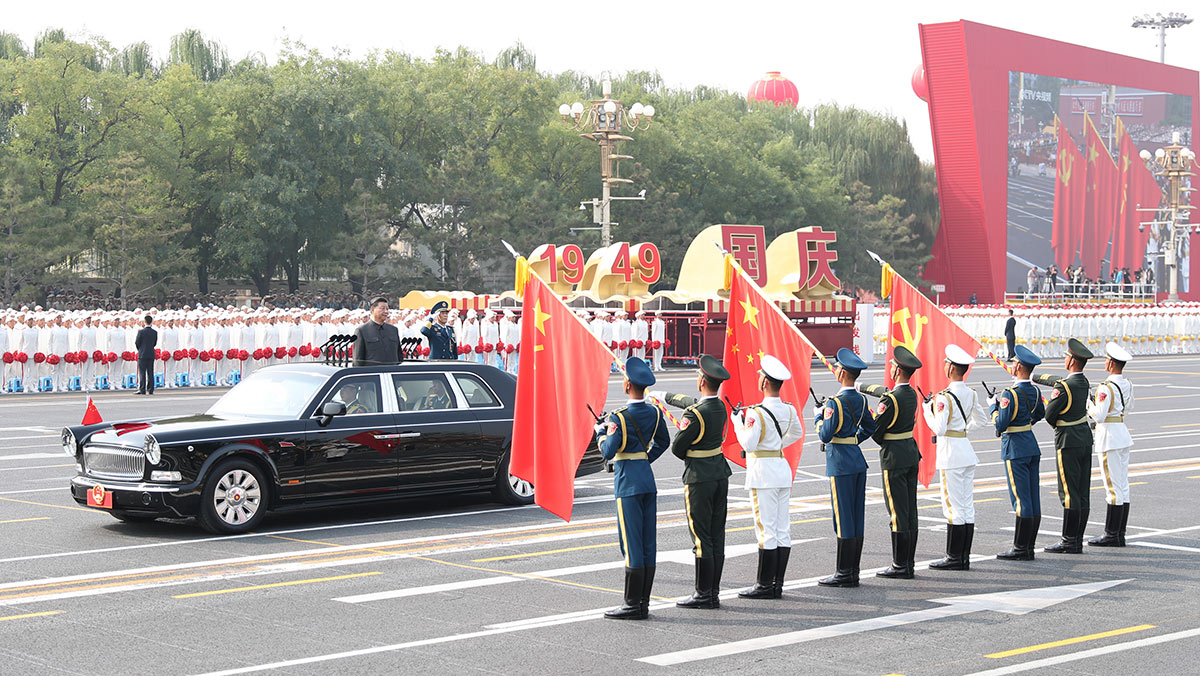 習(xí)近平驅(qū)車行進(jìn)至黨旗、國旗、軍旗前，向旗幟行注目禮