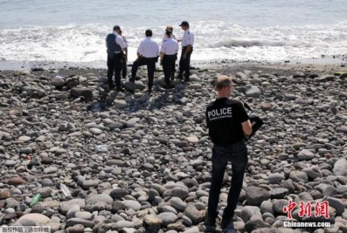 當?shù)貢r間8月2日，法屬留尼旺首府圣但尼附近的一處海灘上，警員正在現(xiàn)場對金屬殘片進行勘察。